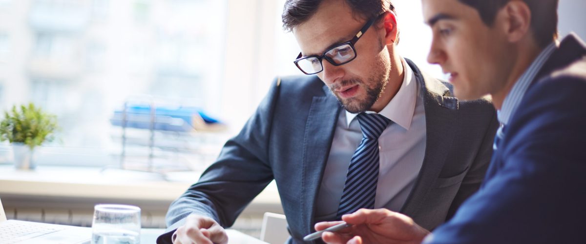 Listening to colleague Serious businessman listening to his colleague explanations at meeting